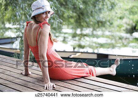 Young woman sitting by a river View Large Photo Image Stock Image - Young woman sitting by a river. Fotosearch
