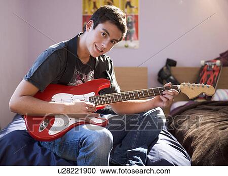 Stock Image - A teenage boy with a guitar. Fotosearch