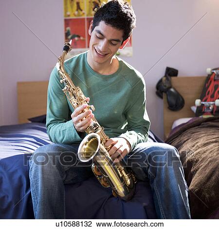 Stock Image - A teenage boy with a saxophone. Fotosearch