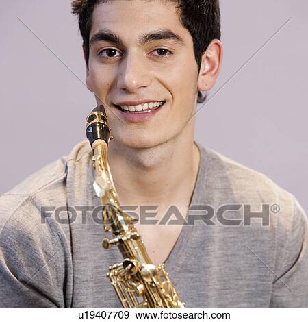 Stock Photo - A teenage boy with a saxophone. Fotosearch