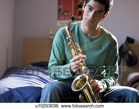 A teenage boy with a saxophone View Large Photo Image Stock Photograph - A teenage boy with a saxophone. Fotosearch