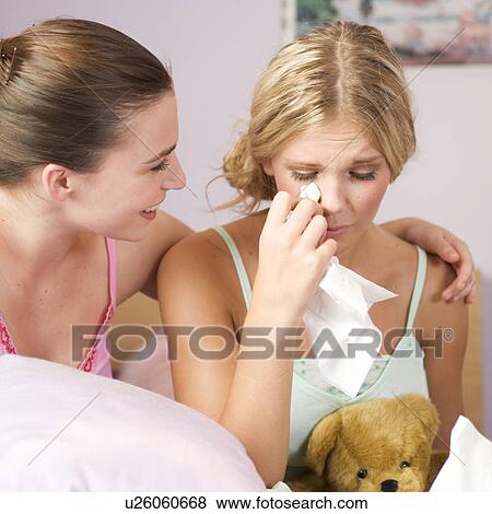 Stock Photo - A teenage girl comforting her friend. Fotosearch