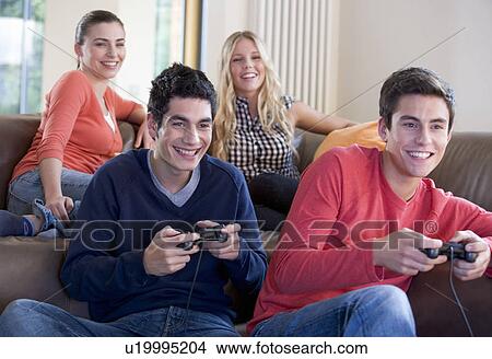 Four teenage friends playing a computer game View Large Photo Image Picture - Four teenage friends playing a computer game. Fotosearch
