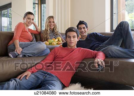 Four teenage friends watching television View Large Photo Image Stock Image - Four teenage friends watching television. Fotosearch