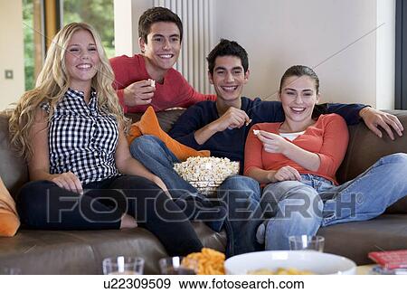 Four teenage friends watching television View Large Photo Image Stock Photo - Four teenage friends watching television. Fotosearch
