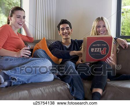 Stock Photo - Three teenage friends eating takeaway pizza. Fotosearch