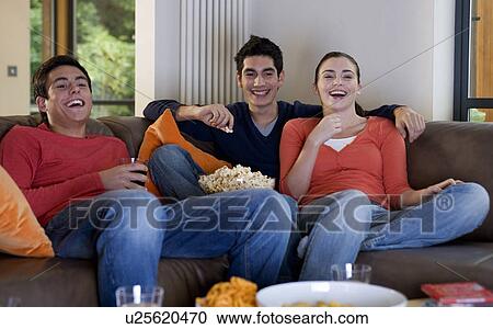 Three teenage friends watching television View Large Photo Image Stock Image - Three teenage friends watching television. Fotosearch