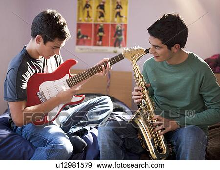 Stock Photo - Two teenage boys playing musical instruments. Fotosearch
