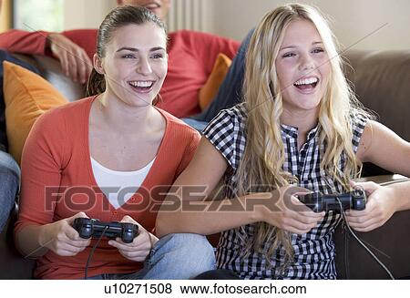 Two teenage girls playing a computer game View Large Photo Image Stock Photo - Two teenage girls playing a computer game. Fotosearch