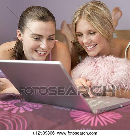 Stock Photograph - Two teenage girls using a laptop. Fotosearch