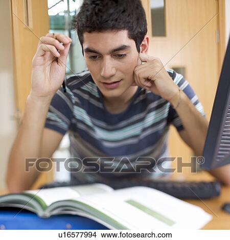 Picture - A teenage boy studying. Fotosearch
