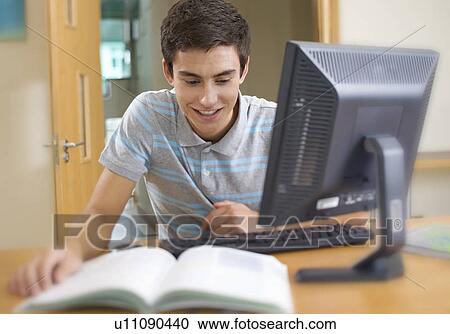 A teenage boy using a computer View Large Photo Image Stock Image - A teenage boy using a computer. Fotosearch