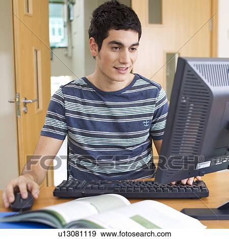 Stock Photo - A teenage boy using a computer. Fotosearch