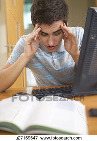 Stock Photo - A teenage boy using a computer. Fotosearch