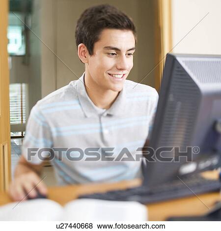 Stock Photo - A teenage boy using a computer. Fotosearch
