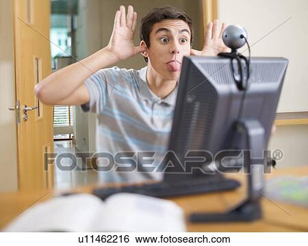 Stock Photograph - A teenage boy using a computer. Fotosearch