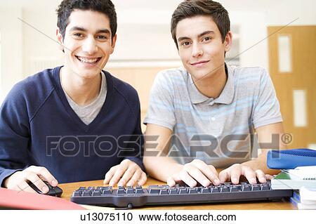 Two teenage boys using a computer View Large Photo Image Stock Image - Two teenage boys using a computer. Fotosearch