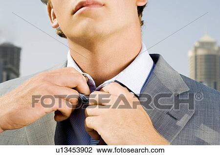 A businessman adjusting his tie View Large Photo Image Stock Image - A businessman adjusting his tie. Fotosearch