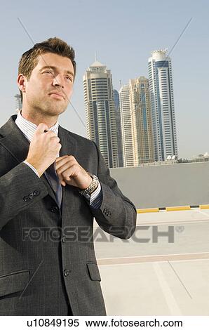 Stock Photography - A businessman adjusting his tie. Fotosearch