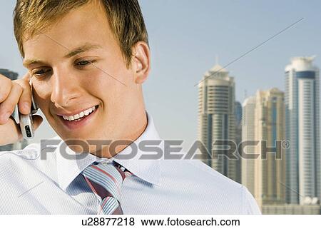 Stock Photo - A businessman talking on a mobile phone. Fotosearch