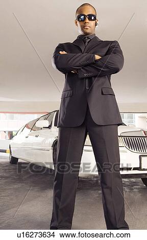 A chauffer standing by a stretch limousine View Large Photo Image Picture - A chauffer standing by a stretch limousine. Fotosearch