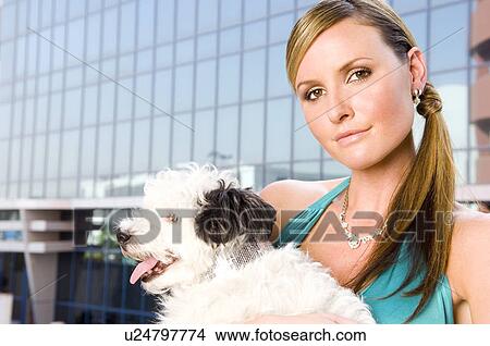 Picture - A woman holding a small dog. Fotosearch