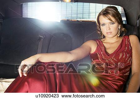 A woman sitting in the back of a car View Large Photo Image Stock Image - A woman sitting in the back of a car. Fotosearch