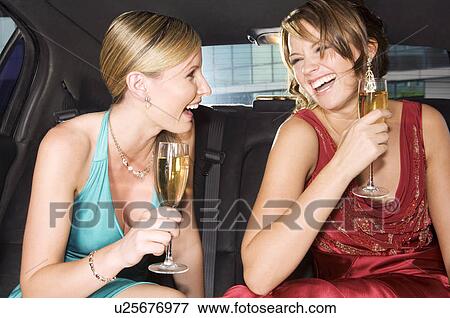 Two women drinking champagne in the back of a car View Large Photo Image Stock Photo - Two women drinking champagne in the back of a car. Fotosearch