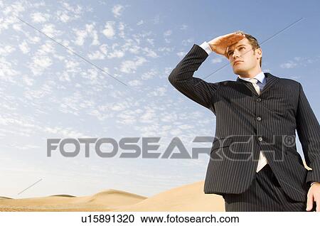 A man in a suit standing in a desert View Large Photo Image Stock Image - A man in a suit standing in a desert. Fotosearch