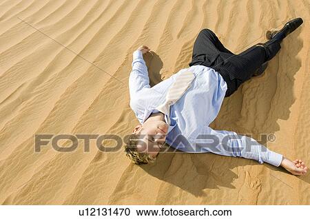 A man laying in a desert View Large Photo Image Stock Image - A man laying in a desert. Fotosearch