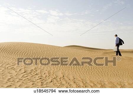 A man with a suitcase walking in a desert View Large Photo Image Picture - A man with a suitcase walking in a desert. Fotosearch