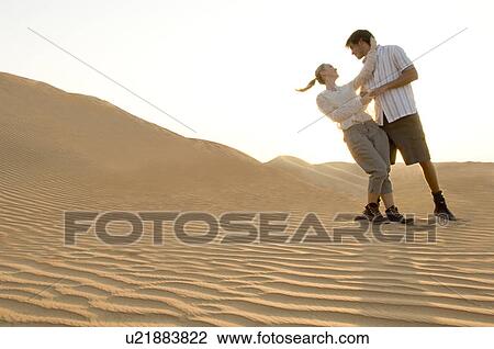 Stock Image - A young couple dancing in the desert. Fotosearch