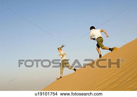 A young couple running in the desert View Large Photo Image Picture - A young couple running in the desert. Fotosearch