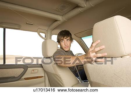 A young man in a car View Large Photo Image Stock Photograph - A young man in a car. Fotosearch