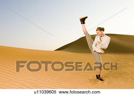 A young woman kick boxing in the desert View Large Photo Image Stock Photography - A young woman kick boxing in the desert. Fotosearch