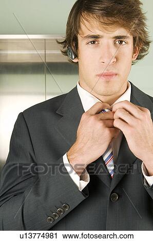 A businessman checking his tie View Large Photo Image Stock Image - A businessman checking his tie. Fotosearch