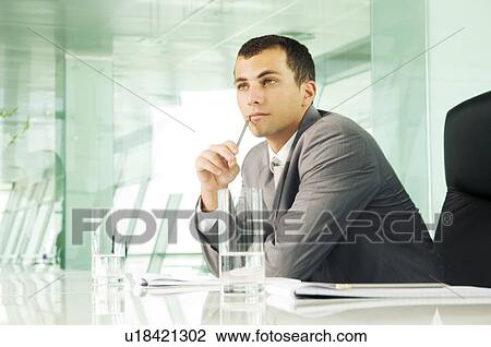 Stock Image - A businessman in a boardroom. Fotosearch