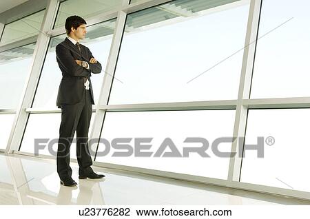 A businessman looking through a window View Large Photo Image Stock Image - A businessman looking through a window. Fotosearch