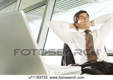 A businessman relaxing at his desk View Large Photo Image Stock Image - A businessman relaxing at his desk. Fotosearch