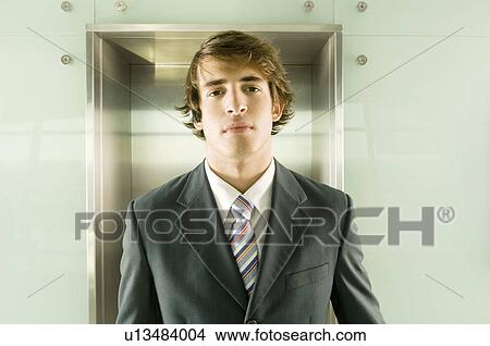 A businessman standing by the lift View Large Photo Image Picture - A businessman standing by the lift. Fotosearch