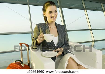 A businesswoman drinking coffee at an airport View Large Photo Image Stock Image - A businesswoman drinking coffee at an airport. Fotosearch