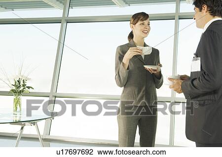 A businesswoman having a cup of coffee with a visiting colleague View Large Photo Image Stock Image - A businesswoman having a cup of coffee with a visiting colleague. Fotosearch
