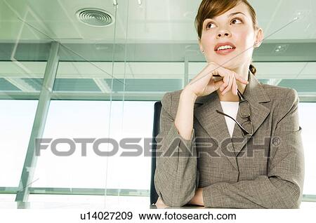 Stock Photo - A businesswoman sitting at a table. Fotosearch