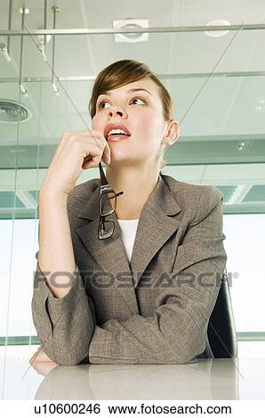 A businesswoman sitting at a table View Large Photo Image Stock Photograph - A businesswoman sitting at a table. Fotosearch