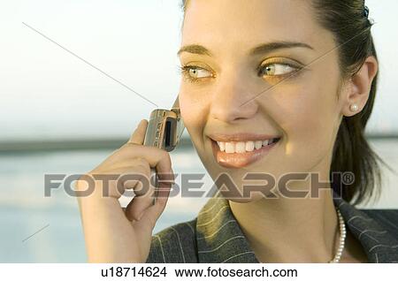 Picture - A businesswoman talking on a mobile phone. Fotosearch