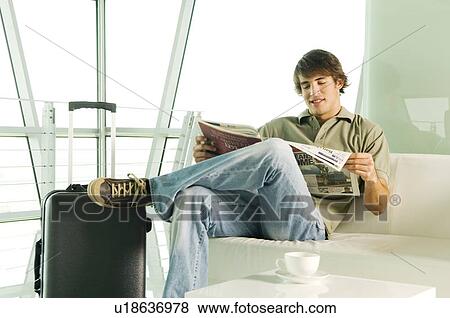 A man with a suitcase waiting in a lobby View Large Photo Image Stock Photo - A man with a suitcase waiting in a lobby. Fotosearch