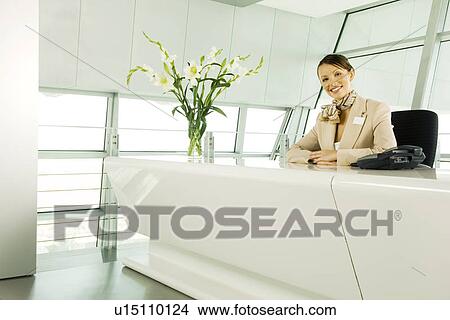 A receptionist sitting at a desk View Large Photo Image Picture - A receptionist sitting at a desk. Fotosearch