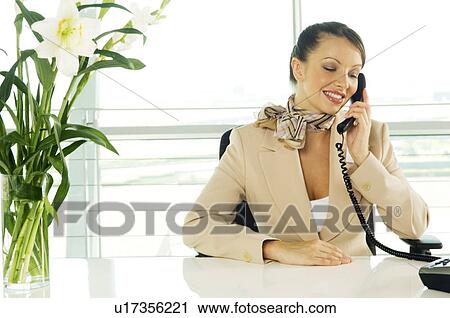 Stock Image - A receptionist talking on the telephone. Fotosearch