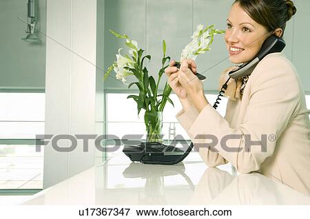 A receptionist talking on the telephone View Large Photo Image Stock Photo - A receptionist talking on the telephone. Fotosearch