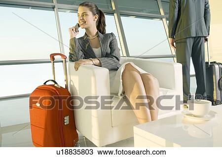 Stock Image - Two travellers at an airport. Fotosearch
